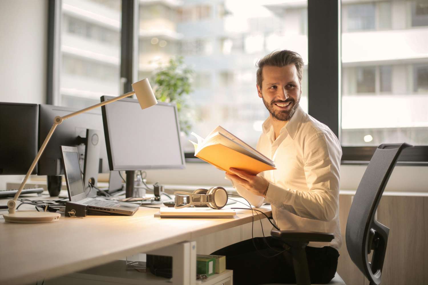 smiling man working at desk with computer