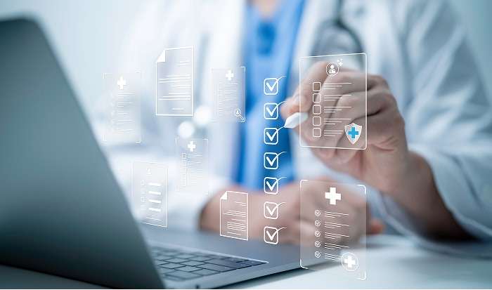 doctor&nbsp;reviewing&nbsp;forms&nbsp;on&nbsp;a&nbsp;computer