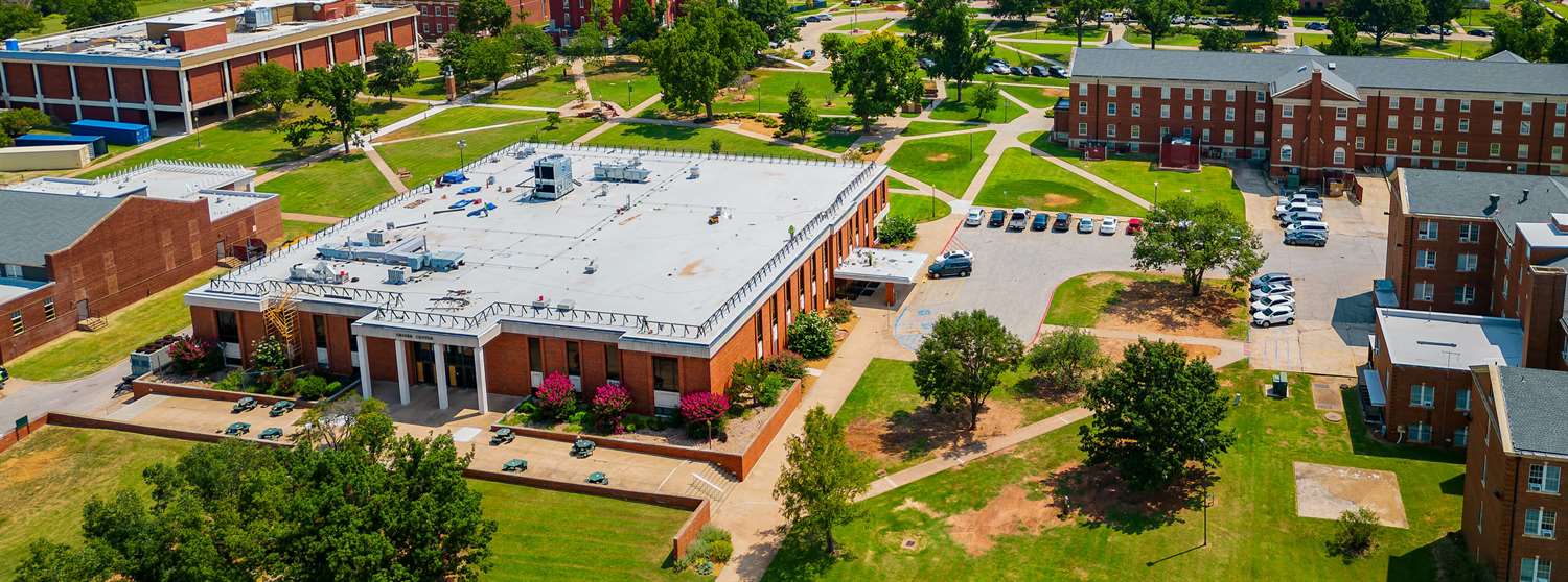 An aerial photo of the Oklahoma Baptist University featuring red brick buildings and green spaces.
