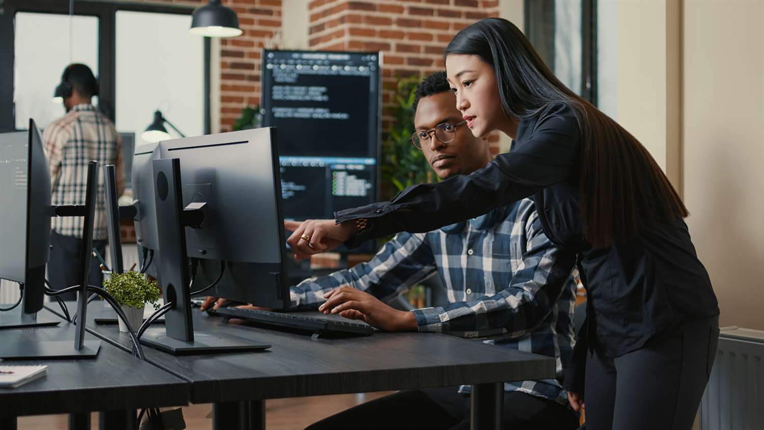 woman pointing out idea on a computer to a man