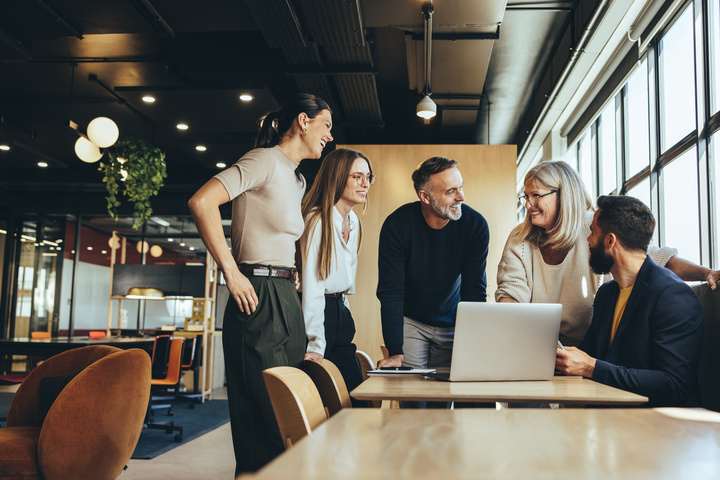 work team meeting around a table looking happy