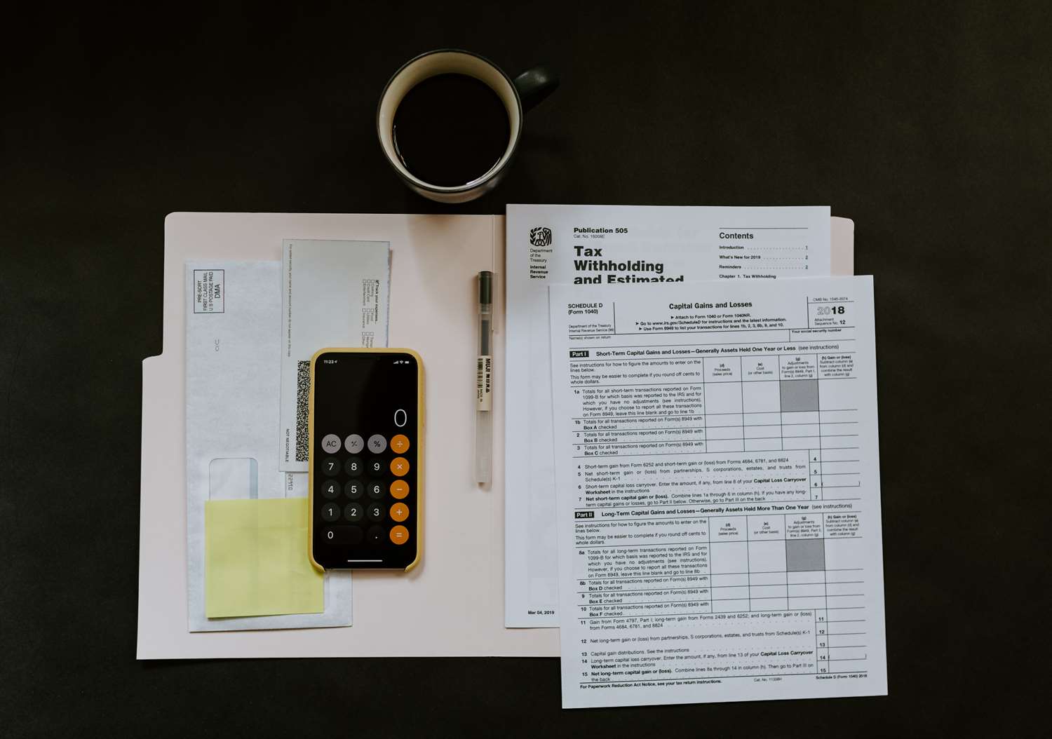 Tax forms and calculator laying with a cup of coffee.