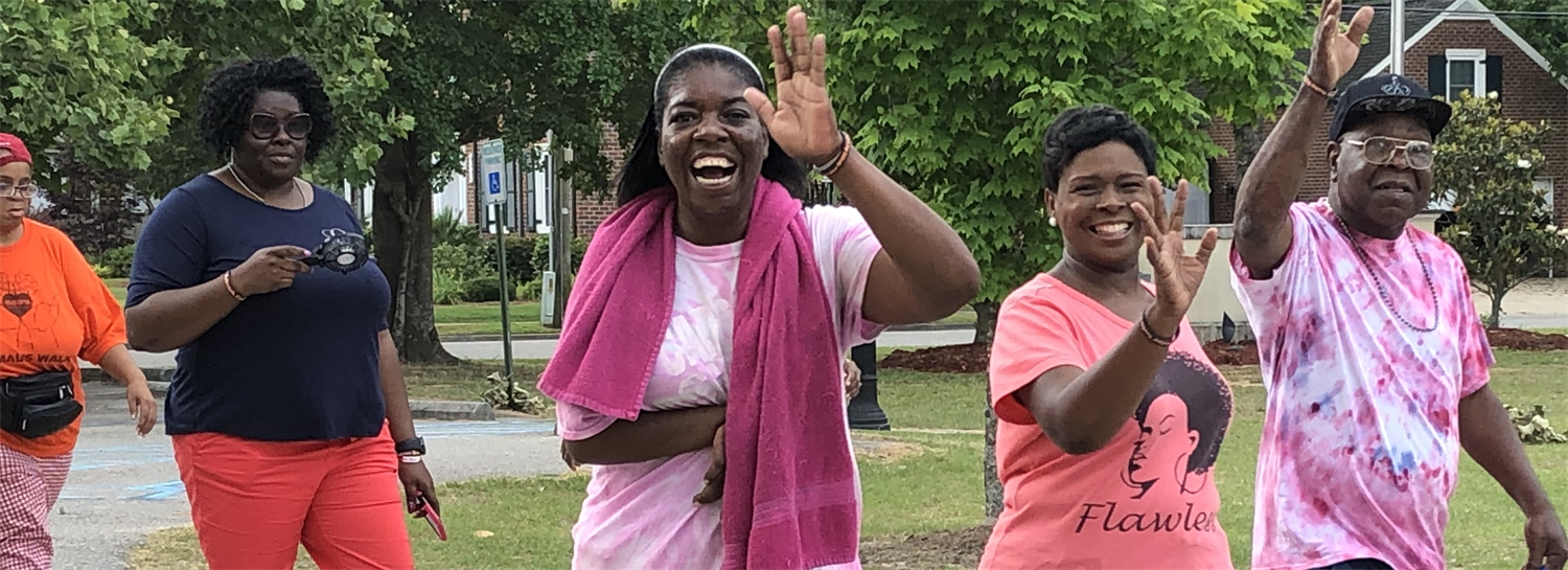 Babcock Center volunteers smiling and waving at the camera.